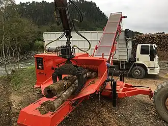 Tree chipper mounted by side to tree processing into biofuel