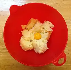 Eggs are added to mashed potatoes.