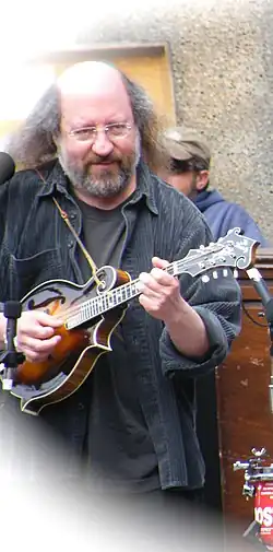 Sandy Rothman on stage, playing a mandolin